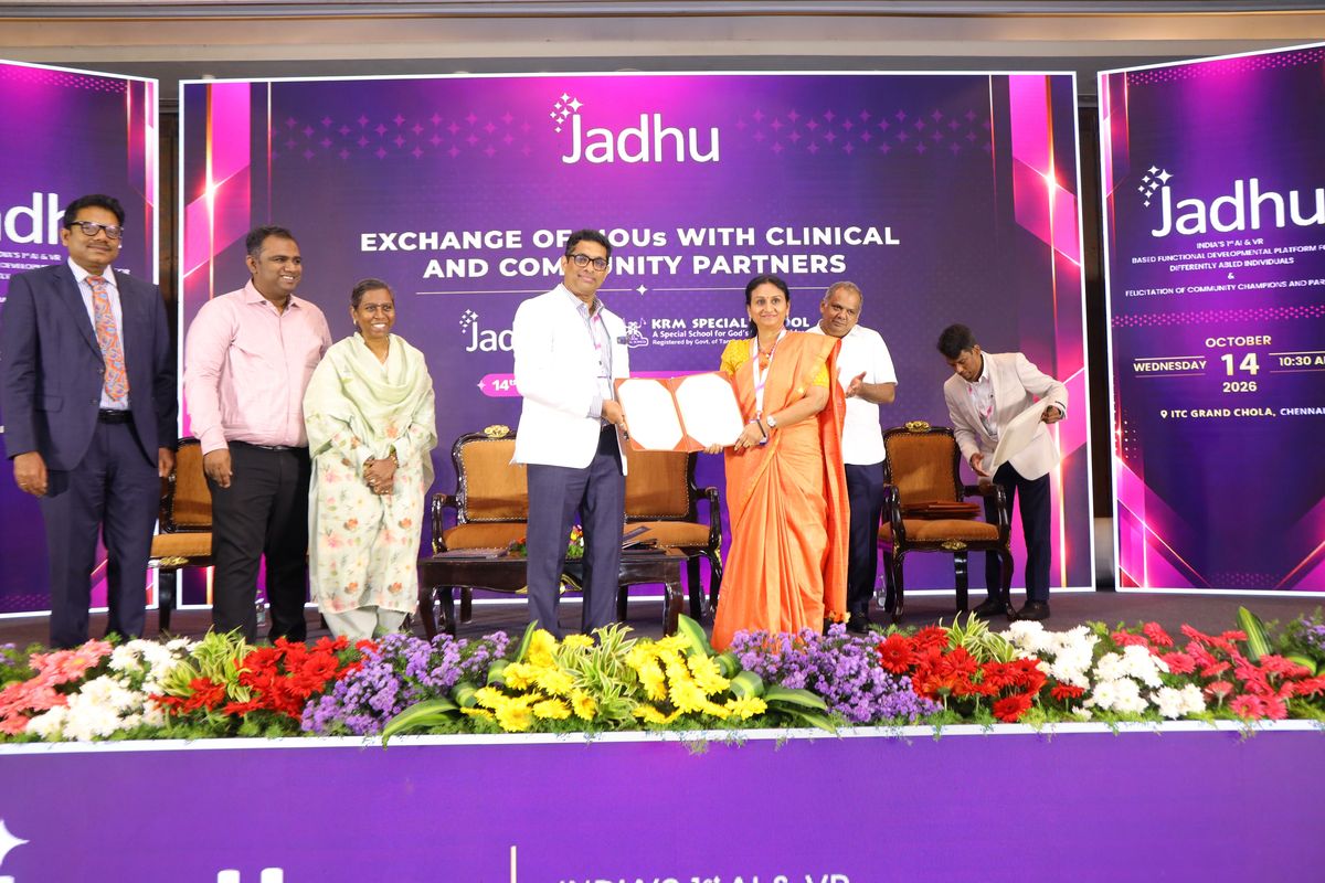 Signed Memorandum of Understanding between Jadhu and KRM Special School, Chennai, held up on stage in front of the Exchange of MOUs backdrop