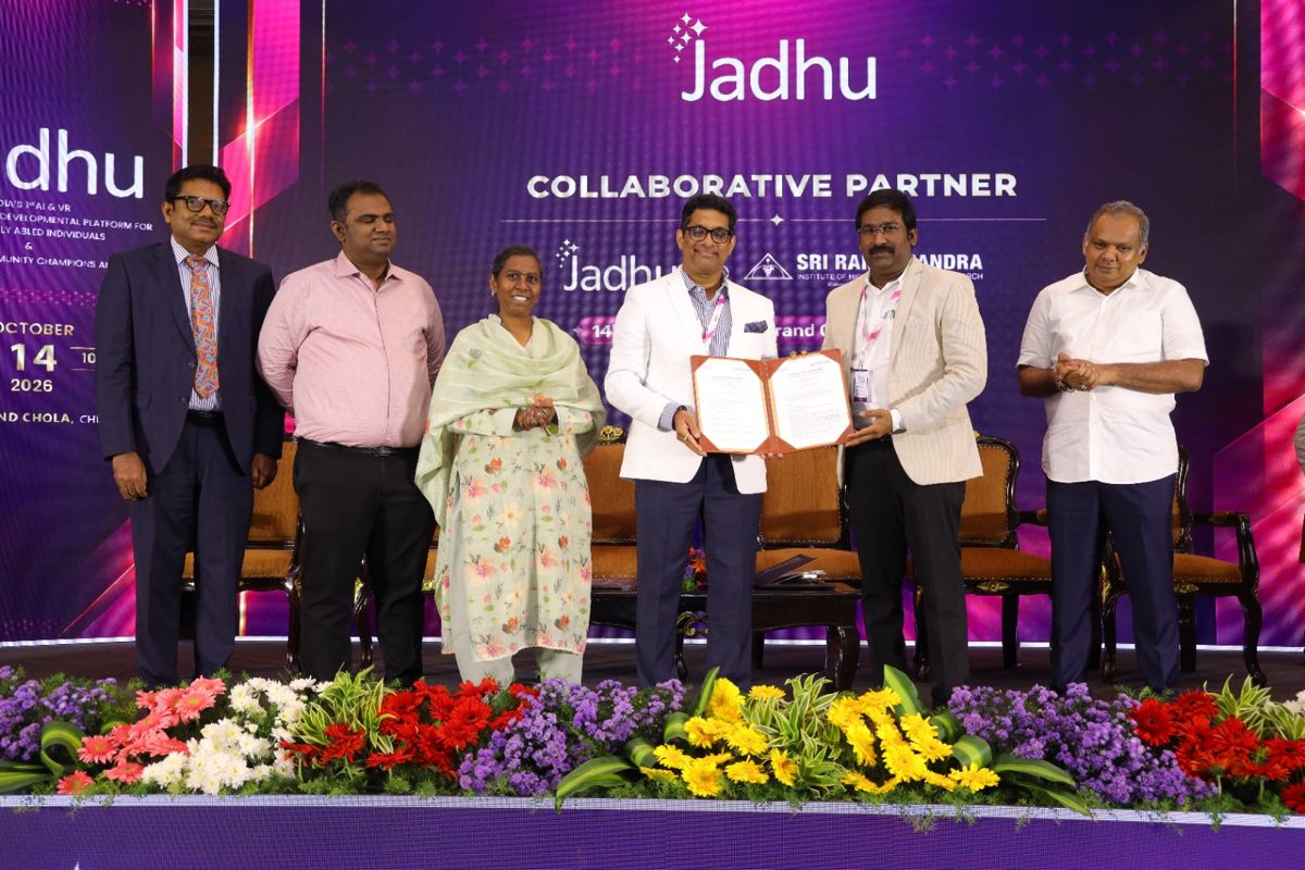 Signed Memorandum of Understanding between Jadhu and Sri Ramachandra Medical Centre, Chennai, held up on stage in front of the Collaborative Partner backdrop